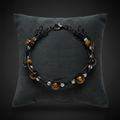 Bracelet œil de tigre fil noir sur coussin anthracite