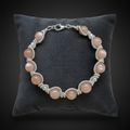 Bracelet pierre de lune pêche sur coussin velours fond noir