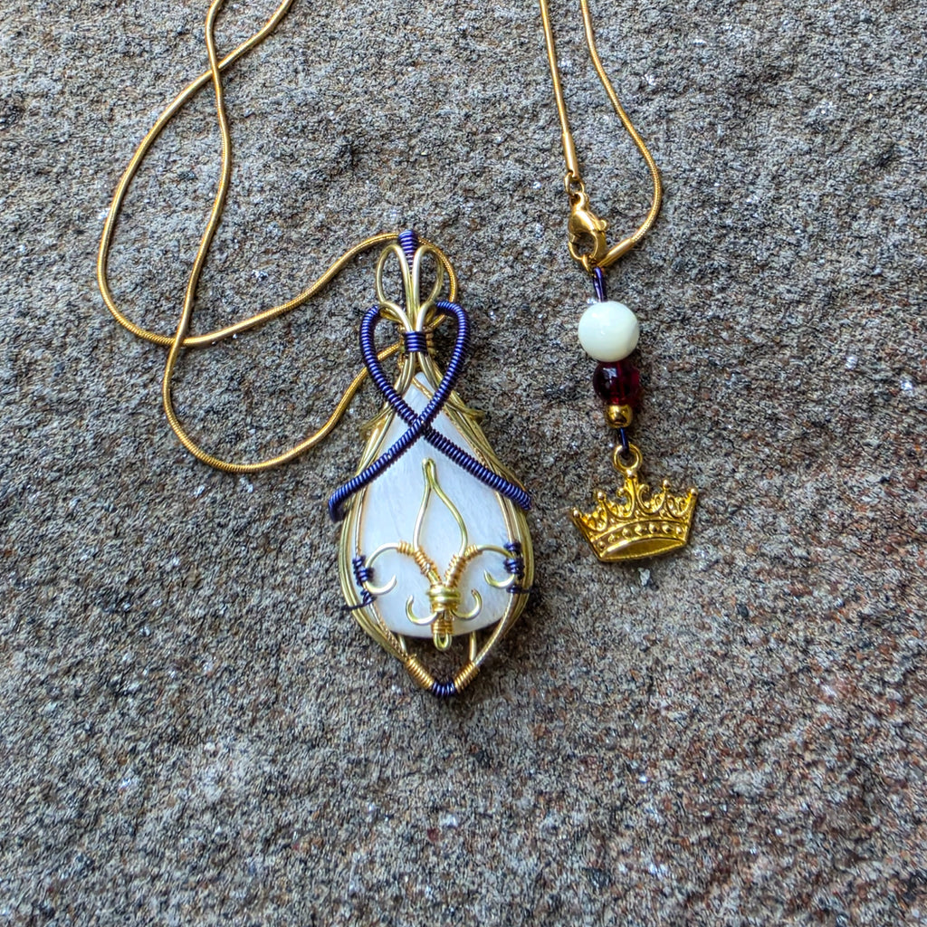 Pendentif artisanal en scolécite et cuivre patiné photographié avec sa chaîne et une petite couronne